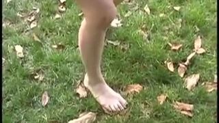 Blonde chick gets her feet dirty outside
